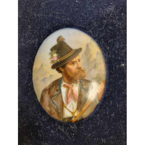 911 - A framed painted oval porcelain panel of an Austrian gentleman in a national costume with mountains ... 