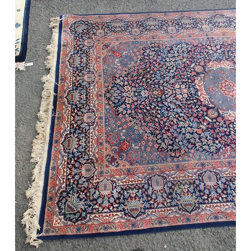 929 - A bordered Persian Carpet with central indigo medallion on a red field with indigo main border, 6ft ... 