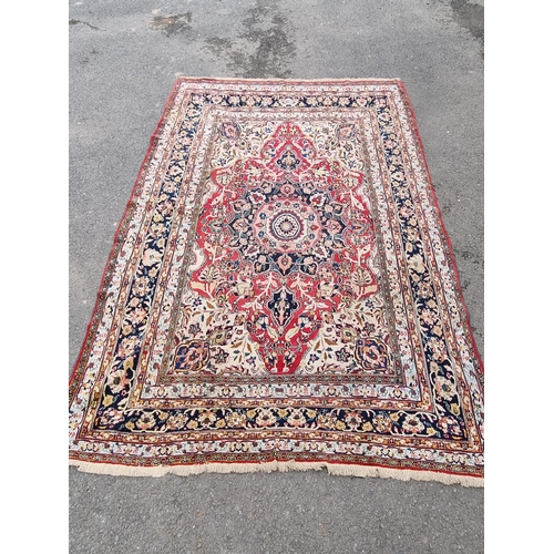 934 - A large bordered Persian Carpet with medallion and corner design on a red and cream ground, the main... 