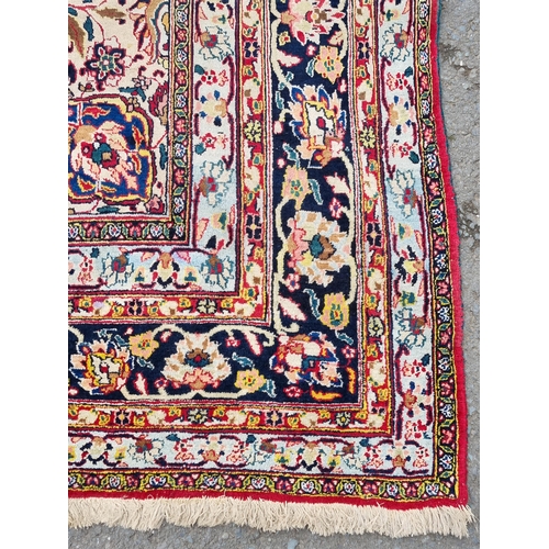 934 - A large bordered Persian Carpet with medallion and corner design on a red and cream ground, the main... 