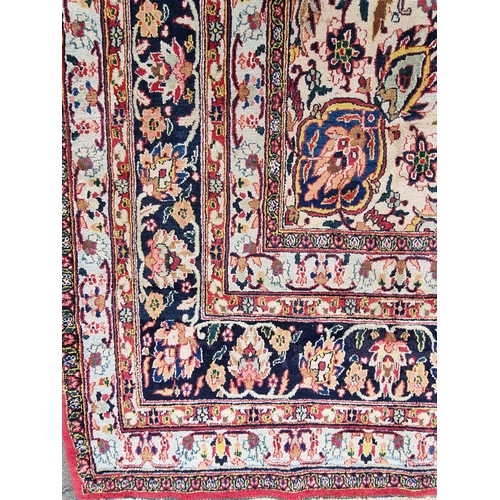 934 - A large bordered Persian Carpet with medallion and corner design on a red and cream ground, the main... 