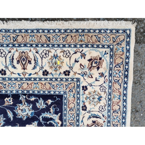 937 - A modern blue ground Persian style Rug with trailing floral design within cream and pink tramline bo... 