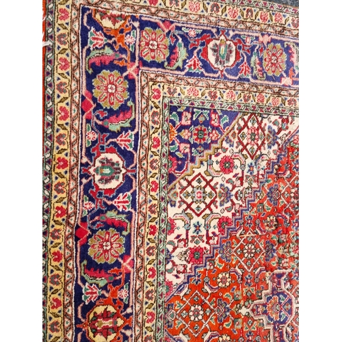 938 - A terracotta ground Persian style Rug with central blue lozenge with stylised floral design within b... 