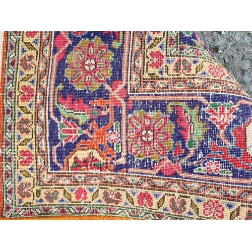 938 - A terracotta ground Persian style Rug with central blue lozenge with stylised floral design within b... 