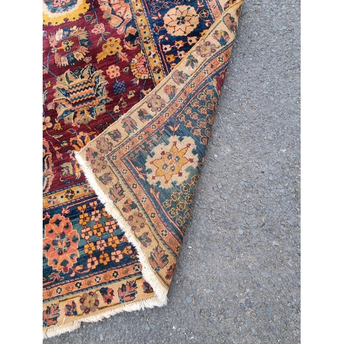 939 - A Oushak type bordered Carpet on red and blue ground, the borders with stylised floral designs, the ... 