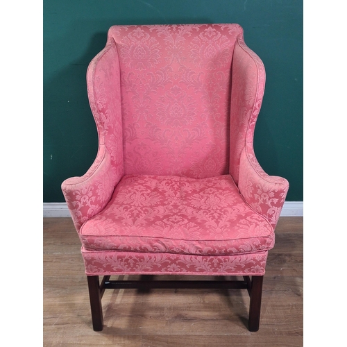 586 - A Georgian style wingback Armchair with scrolled arms and raised on chamfered squared supports and s... 