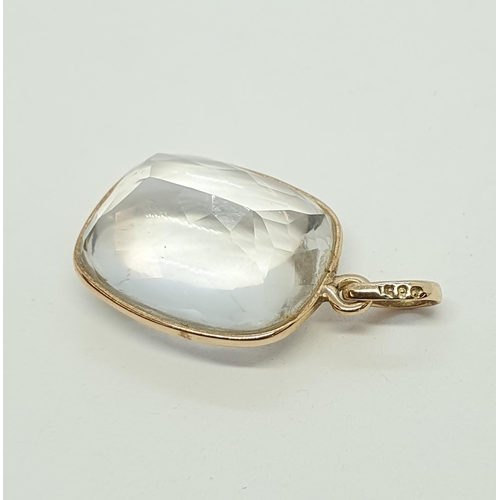 205 - A Rock Crystal Pendant the rectangular cabochon with faceted reverse in gold mount stamped 585