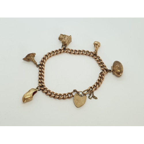 210 - A 9ct gold curblink Charm Bracelet with heart padlock clasp suspending five gold charms including an... 