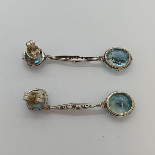 219 - A pair of Zircon drop Earrings each claw-set round stones suspending pierced drop and oval-cut stone... 