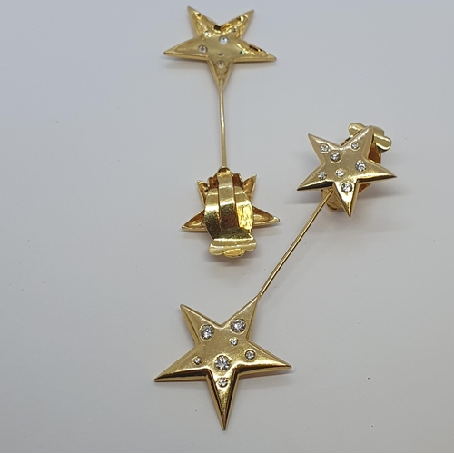 237 - A pair of Diamond Star Ear Clips each with five point star rubover-set brilliant-cut stones suspendi... 