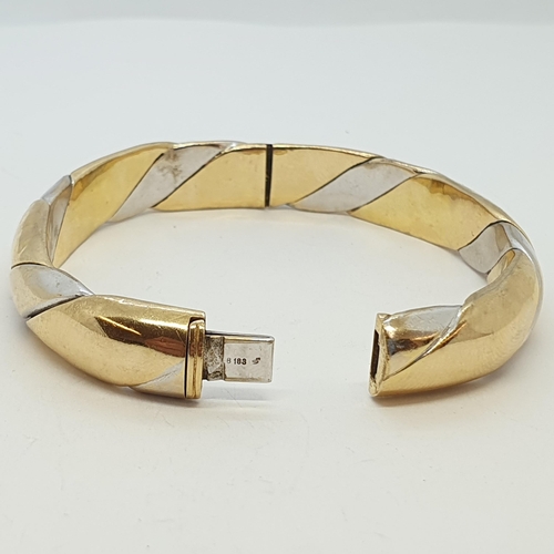 254 - A bi-coloured twist Design Hinged Bangle, stamped 750, approx 37gms