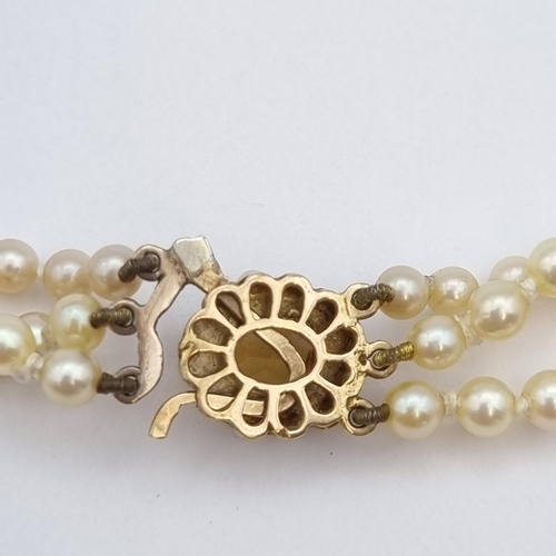 206 - A triple row of graduated Cultured Pearls on clasp set oval-cut citrine within frame of half pearls