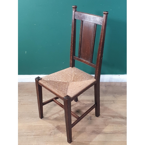 549 - A set of Six oak framed Arts and Crafts splat back chairs with rush seats raised on square supports ... 