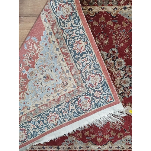 941 - A fine Persian style wool Rug with floral borders and central stylised flower head on a red ground, ... 