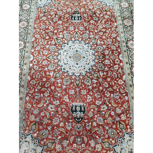 942 - A Persian style fine wool Rug with flower head design to the borders and having central rosette on a... 