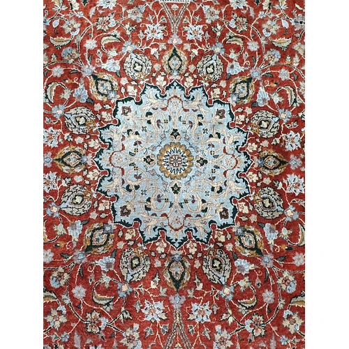 942 - A Persian style fine wool Rug with flower head design to the borders and having central rosette on a... 