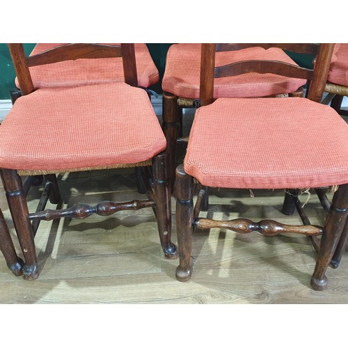 567 - A set of eight 19th Century ash and elm ladderback Chairs with rush seats and squab cushions on turn... 