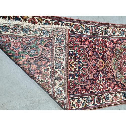 932 - A bordered Persian Runner with geometric floral field in red, blue, cream, etc within tramline borde... 