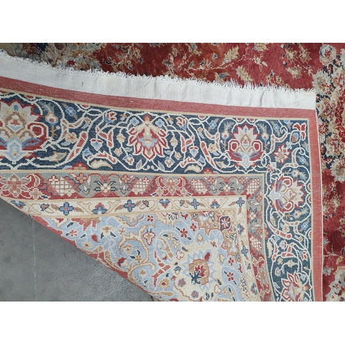 941 - A fine Persian style wool Rug with floral borders and central stylised flower head on a red ground, ... 