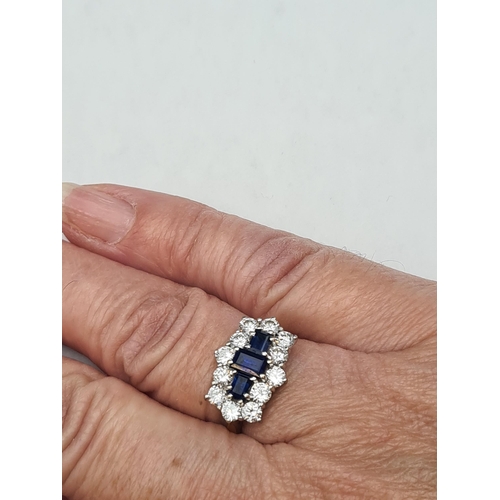 171 - A Sapphire and Diamond Cluster Ring claw-set three step-cut sapphires within a frame of twelve brill... 