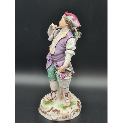 51 - A Meissen Figure of a Youth carrying panniers of grapes, painted costume, on scroll moulded circular... 