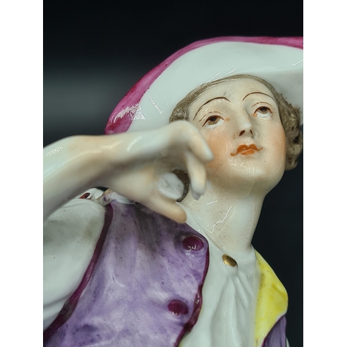 51 - A Meissen Figure of a Youth carrying panniers of grapes, painted costume, on scroll moulded circular... 