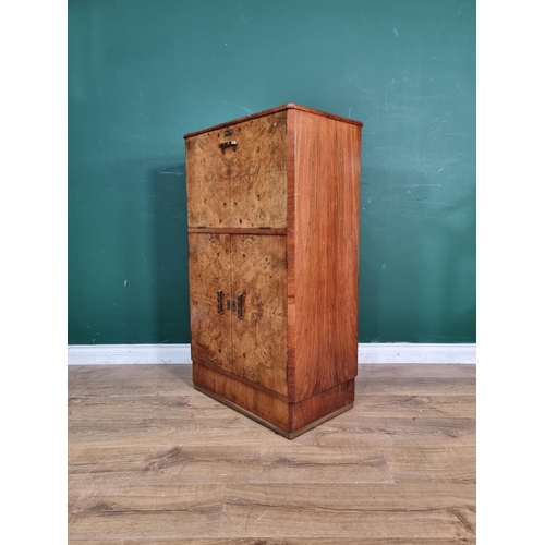 543 - A walnut veneered Cocktail Cabinet with lifting lid enclosing fitted interiors above pair of cupboar... 