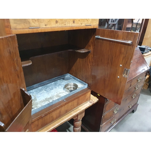 543 - A walnut veneered Cocktail Cabinet with lifting lid enclosing fitted interiors above pair of cupboar... 