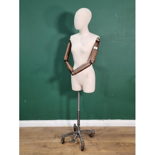 569 - A Dressmaker's Mannequin with wooden hinged arms on metal adjustable base 5ft 4in H (R6)