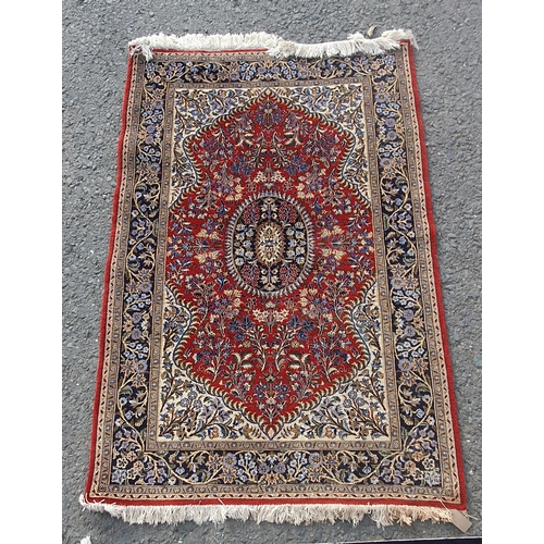 576 - A bordered Persian Rug with central indigo medallion on a madder field, ivory spandrels and indigo m... 