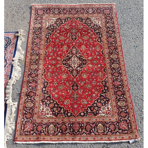 577 - A bordered Persian Carpet with central indigo medallion on a red field with indigo main border, 4ft ... 