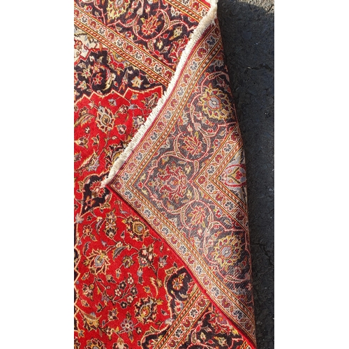 577 - A bordered Persian Carpet with central indigo medallion on a red field with indigo main border, 4ft ... 