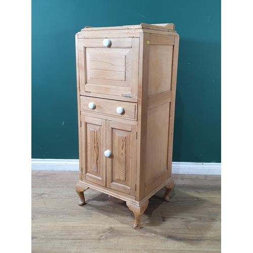 590 - An antique pine Cabinet with fall front above central drawer and pair of cupboard doors raised on ca... 