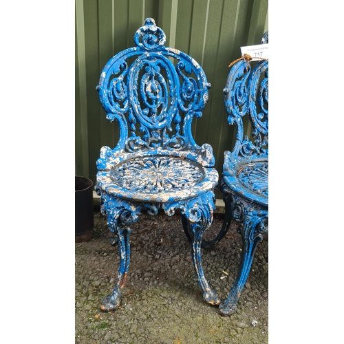 717 - A set of four cast iron Garden Seats with pierced and scrolled designs, later painted blue, and two ... 