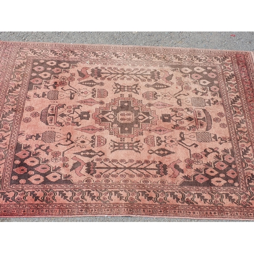 860 - A pale red multi-bordered Persian Rug with stylised design, depicting birds, 6ft 6in L x 4ft W