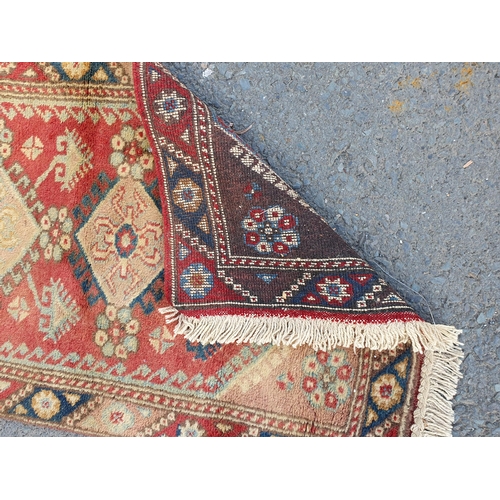 867 - A Runner on red ground with multi-floral borders with seven central stylised medallions, 10ft L x 2f... 