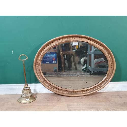 870 - A gilt framed oval Wall Mirror 2ft 5in W x 1ft 11in H and an antique brass Door Stop 1ft 4in H (R5)