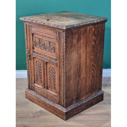 39 - A carved oak Cupboard with single panel door with carved leafage decoration and raised on plinth bas... 