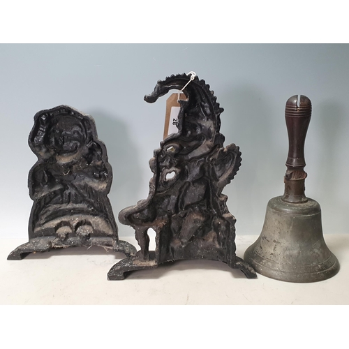 28 - A pair of cast iron Punch and Judy Doorstops and a Hand Bell with turned wooden handle, handle A/F. ... 