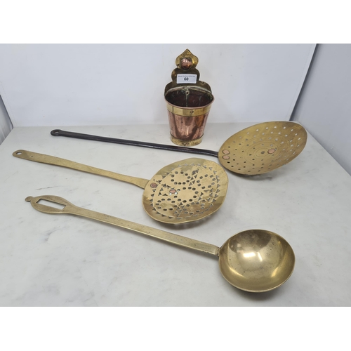 60 - Two antique brass Skimmers, a brass Ladle and a copper and brass circular Wall Pocket. (R2)