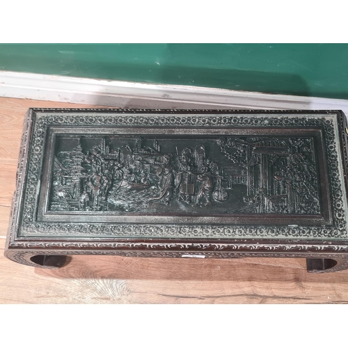 743 - An Eastern style carved low Table with relief design of figures in a landscape, on scrolled supports... 