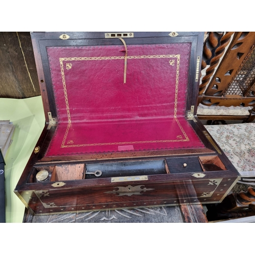 745 - A fine rosewood Writing Box with brass inlay, having a pair of brass candlesticks mounted when open,... 