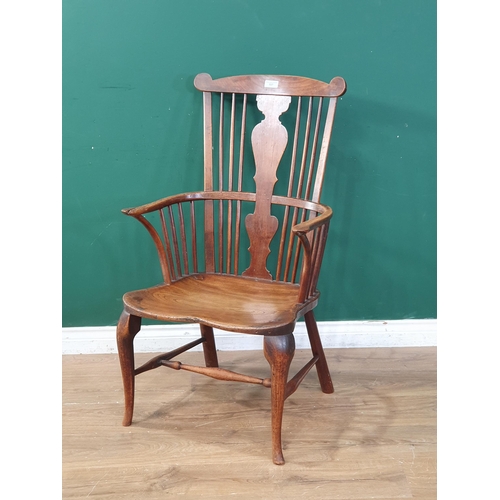 569 - A 19th Century elm seated Elbow Chair with splat back, shaped seat on slender cabriole front support... 