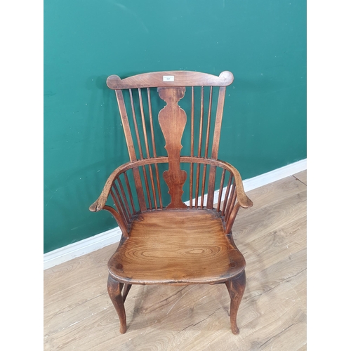 569 - A 19th Century elm seated Elbow Chair with splat back, shaped seat on slender cabriole front support... 