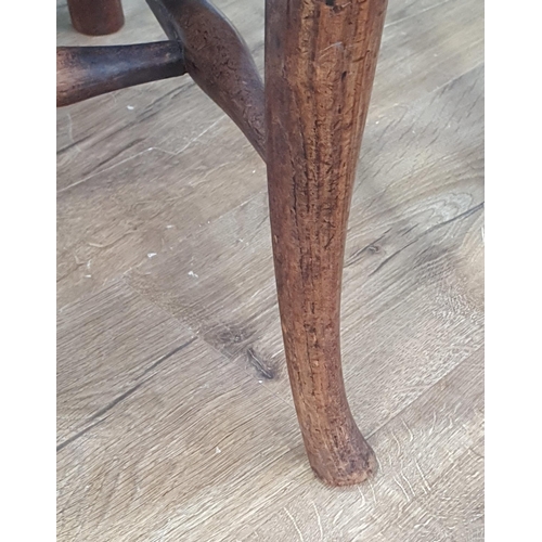 569 - A 19th Century elm seated Elbow Chair with splat back, shaped seat on slender cabriole front support... 