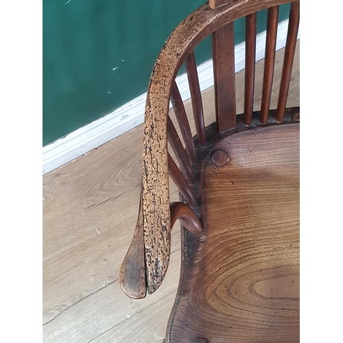 569 - A 19th Century elm seated Elbow Chair with splat back, shaped seat on slender cabriole front support... 