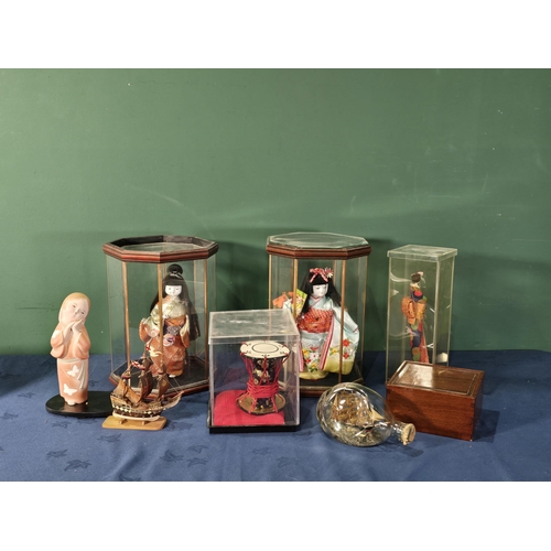 270 - Two Japanese Dolls in octagonal glazed cases, another Japanese Doll in a case, a pottery Japanese st... 