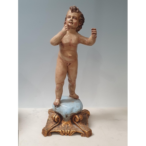 350 - A clay polychrome Figure of a Putti on square scroll base in the Rococo manner 12 1/4in H