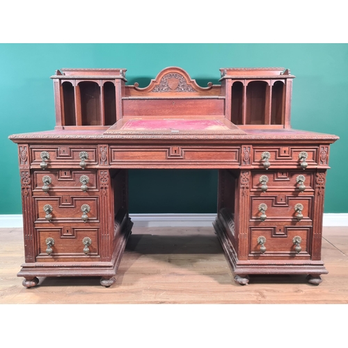 187 - A Victorian carved oak Pedestal Desk, the raised top fitted letter compartment and pigeonholes with ... 