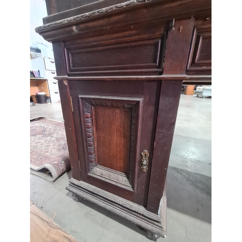 187 - A Victorian carved oak Pedestal Desk, the raised top fitted letter compartment and pigeonholes with ... 